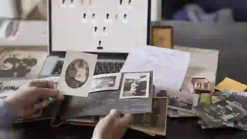 A photo of a family looking through a printed photo album with expressions of nostalgia and joy on their faces
