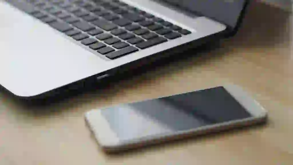 A smartphone and a laptop side by side both displaying contact lists that look identical